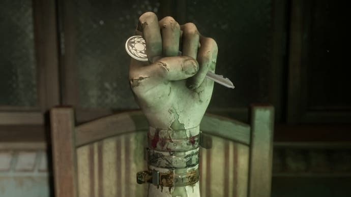 A hand statue holding a key with three medical bracelets attached in Silent Hill 2.