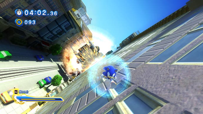 Sonic the blue hedgehog runs along the side of a building chased by a giant truck