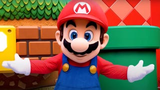 A Super Nintendo World promotional image showing a theme park mascot version of Mario with his arms outstretched.