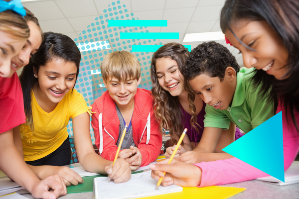 Young students gather around classroom table to practice active learning and write in notebooks.