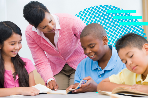 Teacher gives feedback to smiling students while they work