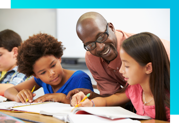 A teacher talks with two young students about books. 